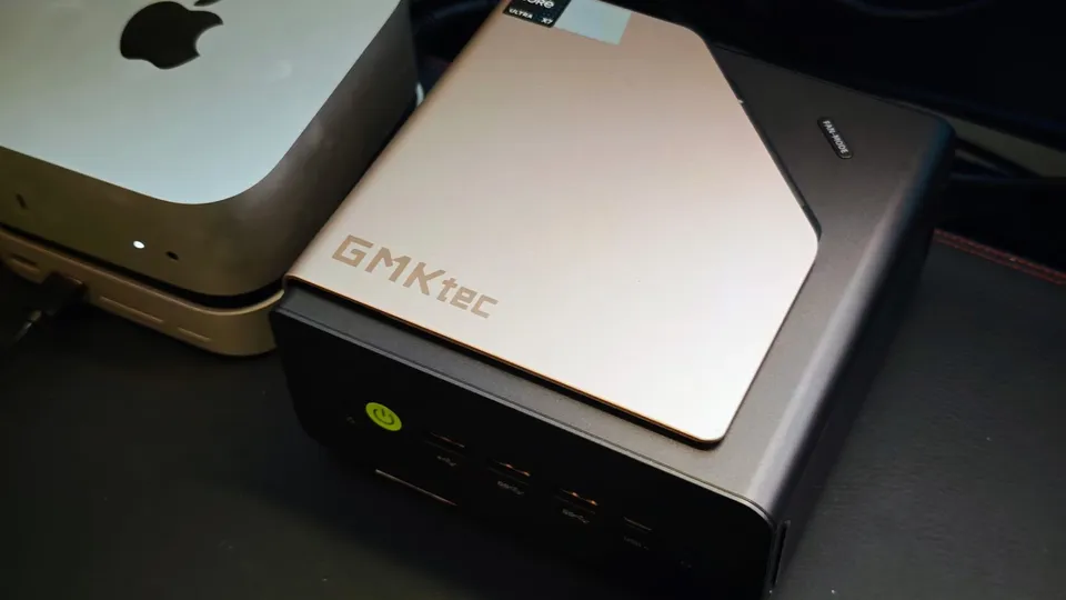 GMKtec EVO-T2S, mini-PC noir au capot argenté gravé GMKtec, à côté d'un Mac mini
