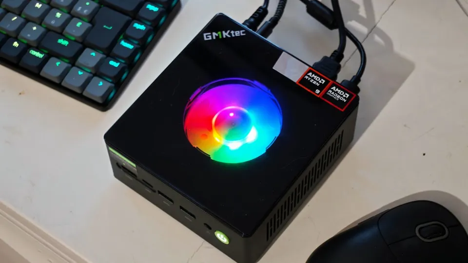 GMKtec NucBox K11, mini-PC noir au ventilateur RGB lumineux sur le dessus, posé près d'un clavier